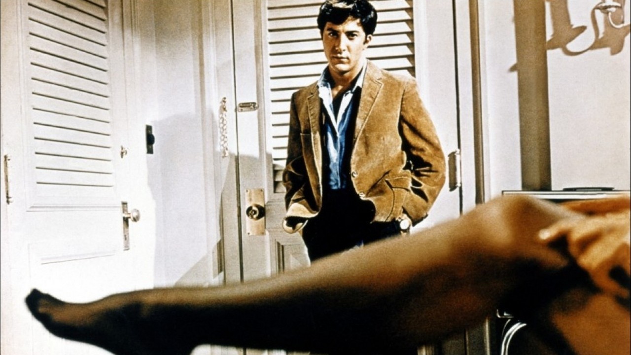 Dustin Hoffman looks at a woman's outstretched leg in a sheer stocking