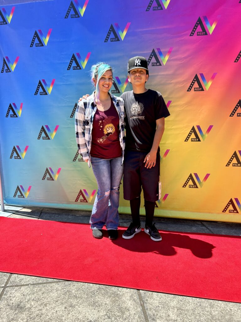 Mother and son pose for AVFilm Summer Film Camp red carpet step and repeat at La Luz Center.